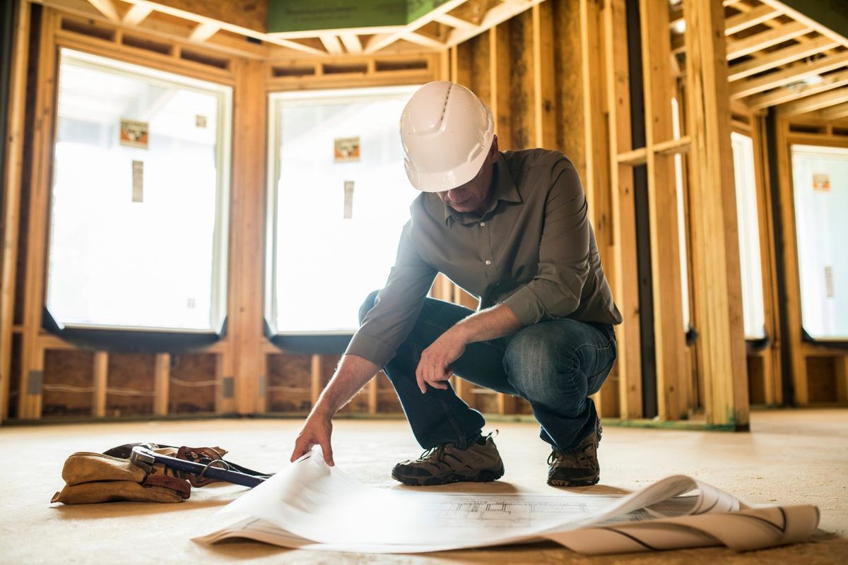 General contractor reviewing repair plans on a job site